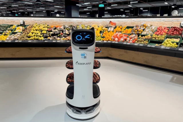 Pudu BellaBot von RoboPlanet mit Häppchen auf den Ablagen im Obsttheken Bereich im Edeka