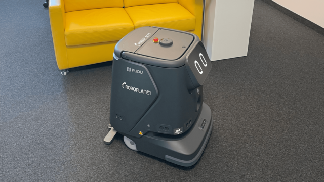 Roboter Pudu CC1 Pro von RoboPlanet beim Saugen von Büro mit Teppich