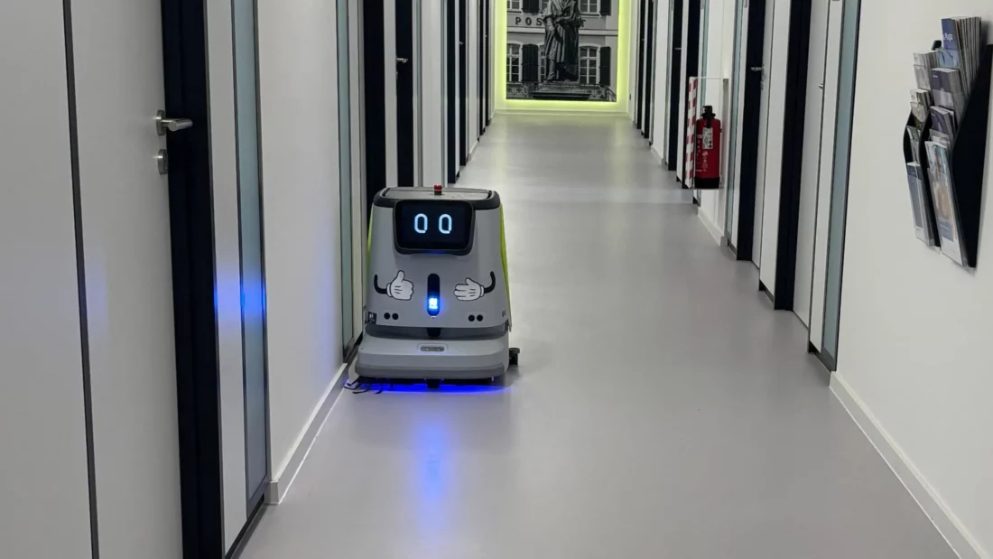 Roboter Pudu CC1 von RoboPlanet beim Reinigen eines Bürogangs