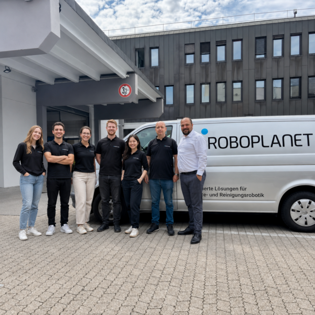 RoboPlanet Servicetechniker Team im Hof mit RoboPlanet Transporter