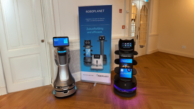 Pudu KettyBot Pro mit Werbescreen und OrionStar Nova auf einer RoboPlanet Veranstaltung